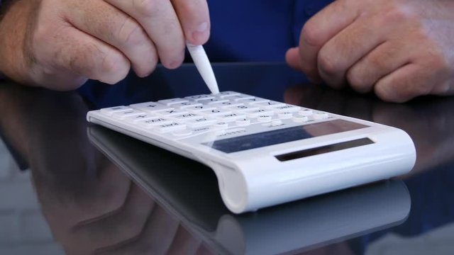 Man Hands Image on the Desk Calculating Using a Pen and Adding Machine