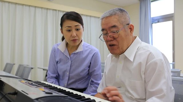 ピアノを習う高齢の男性