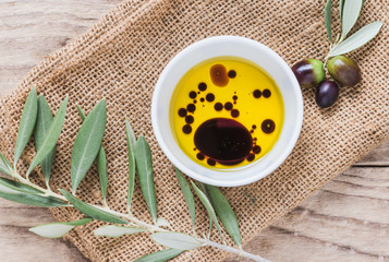 Olive oil and vinegar on wooden background.