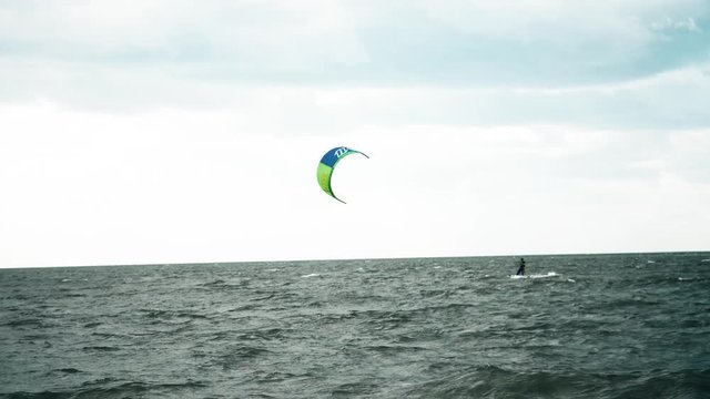 People kitesurfing in ocean. Extreme kite boarding in real time. Summer fun action sports. Kiteboarding at sunrise, active lifestyle extreme sport.