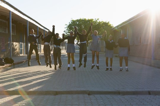 Schoolkids holding hands in school campus