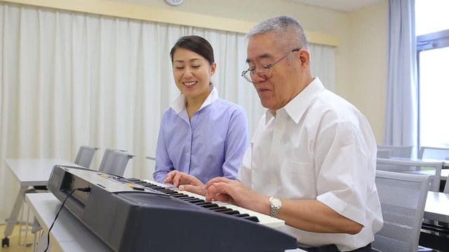 ピアノを習う高齢の男性