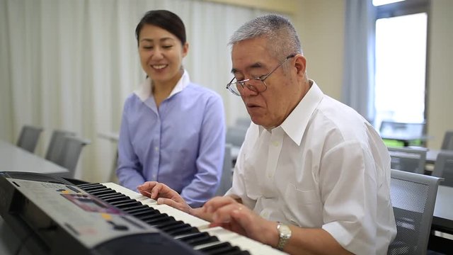 ピアノを習う高齢の男性