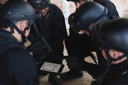 Military soliders discussing their plan over digital tablet