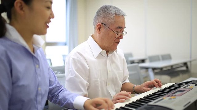 ピアノを習う高齢の男性