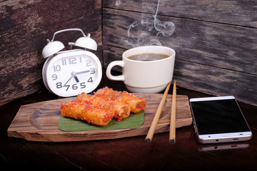 Hot coffee , smartphone  and alarm clock with popia on the table : Concept for coffee time