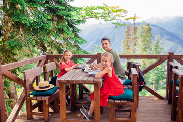 Beautiful happy father with kids in mountains in the background of fog © travnikovstudio