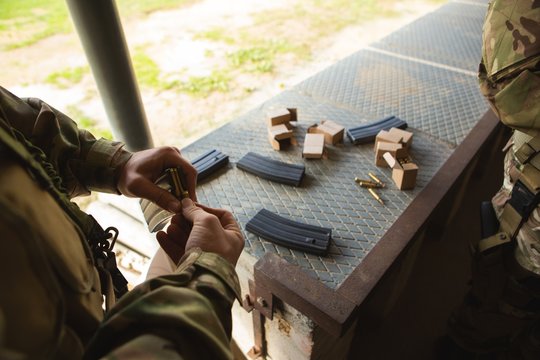 Military soldiers loading bullets in magazine