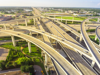 Fototapeta premium Horizontal aerial view massive highway intersection, stack interchange at sunset in Houston, Texas, US. Elevated road junction overpass, five-level freeway infrastructure carry heavy rush hour traffic