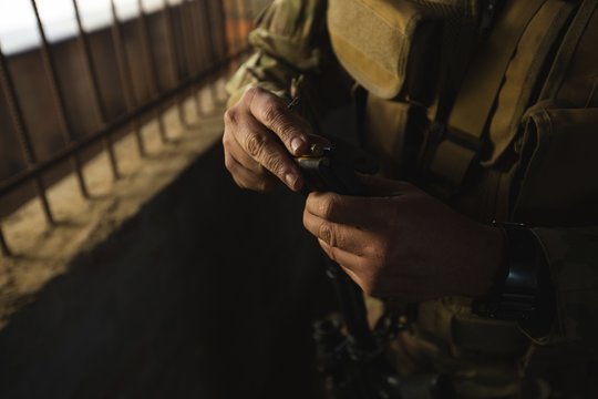 Military soldiers loading bullets in magazine