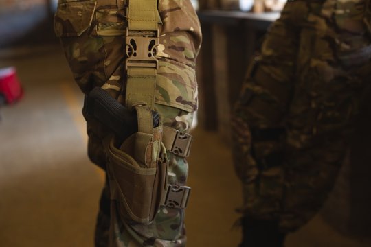 Military soldier standing with pistol during military training