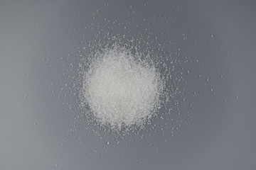 Pile of sugar on gray background.