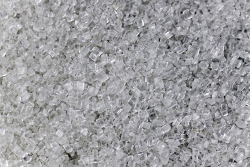Pile of sugar on gray background.