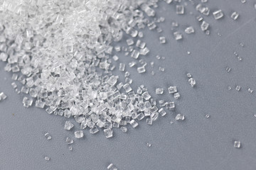 Pile of sugar on gray background.