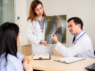 Fototapeta premium healthcare concept.Doctor In Consultation With Patient.Man in lab Coats holding tablet and stethoscope on nack pointing to x ray film.