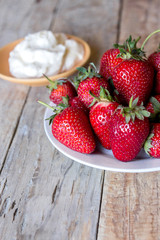delicious strawberry with sweet whipped cream on a wooden table