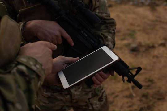 Military soldiers using digital tablet during military training