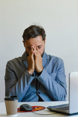 a man working at a computer thought and folded his arms in the face