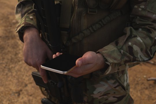 Military soldier using mobile phone during military training