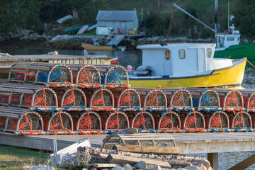 Fototapeta na wymiar lobster traps on dock with fishing boats in harbor