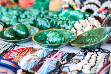 Colorful traditional handmade african malachite eggs, beads and leather necklaces, braceletes and other accessories at local craft market, Cape Town, Soth Africa. Selective focus