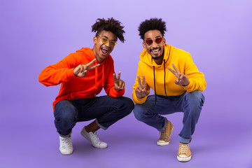 Two happy african man friends dressed in colorful hoodies