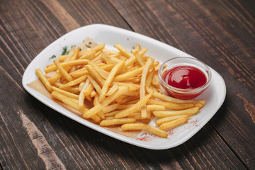 Beer snack - fried potatoes with ketchup on a white plate