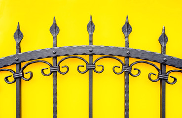 wrought iron fence on yellow background