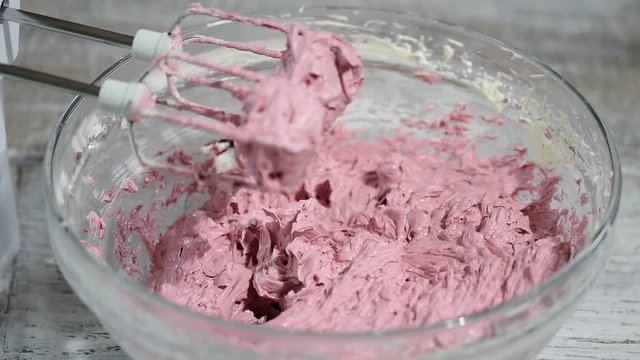 Beat with a mixer berry cream. The process of working in the kitchen.