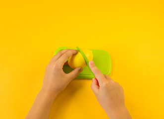 A child cuts a plastic fruit on a board