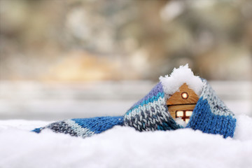 property insurance against natural phenomena/ small wooden house in a warm blue scarf in covered...