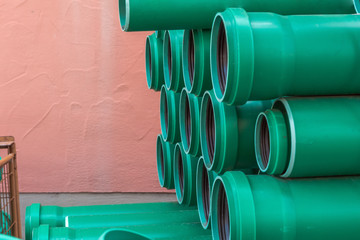A stack of plastic green water pipes of different sizes. Concept: prevention or technology
