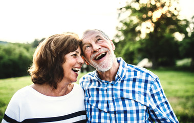 A laughing senior couple in love outdoors in nature.