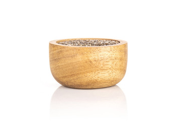 Lot of whole fresh mottled chia seeds with wooden bowl isolated on white background