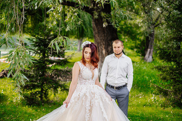 Bride and groom in a park kissing. Young wedding couple newlyweds bride and groom at a wedding in...