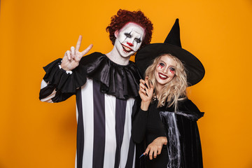 Smiling woman witch and clown looking camera and smiling isolated
