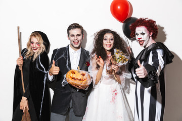 Group of excited friends dressed in scary costumes