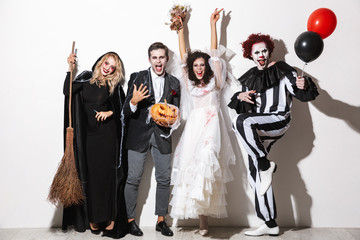 Group of friends dressed in scary costumes celebrating