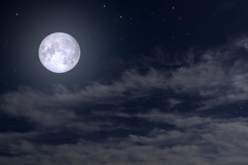Fototapeta na wymiar The full moon between the clouds in the night sky