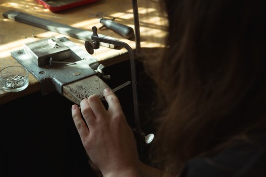 Jewelry designer using a machine in workshop