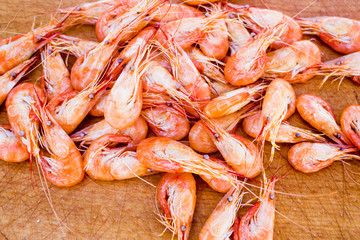 boiled red shrimps on wooden tray, seafood background