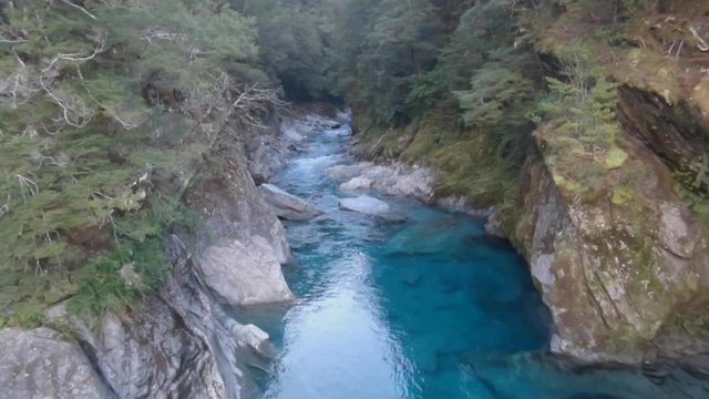 Beautiful view from a suspension bridge on crystal clear water in a river in New Zealands.