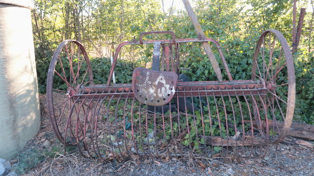 Surcador o arado viejo. Apero de labranza  antiguo de hierro entre la vegetaci&oacute;n