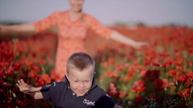 Mother and son running in a field of poppies in Denmark