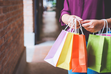 Fototapeta na wymiar Fashion shopping girl, Young woman carrying colorful shopping bags while walking along the shopping mall