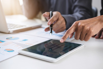 Fototapeta premium Co working conference, Business team meeting present, investor colleagues discussing new plan financial graph data on office table with laptop and digital tablet, Finance, accounting, investment