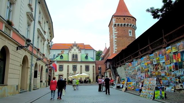 KRAKOW, POLAND - JUNE 12, 2018: Architectural ensemble of Pijarska street with tower of St Florian Gate, Czartoryski Palace, old mansions and art fair along the city wall, on June 12 in Krakow.