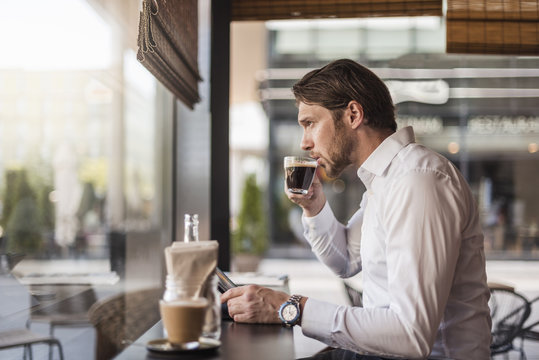 Man Drinking Coffee In Cafe