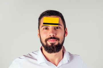 business man in a white shirt holding yellpw credit card . Looking at camera, smiling . black friday sale and spend money concept