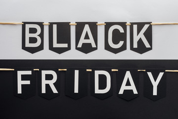 black friday lettering on flag garlands on black and white background